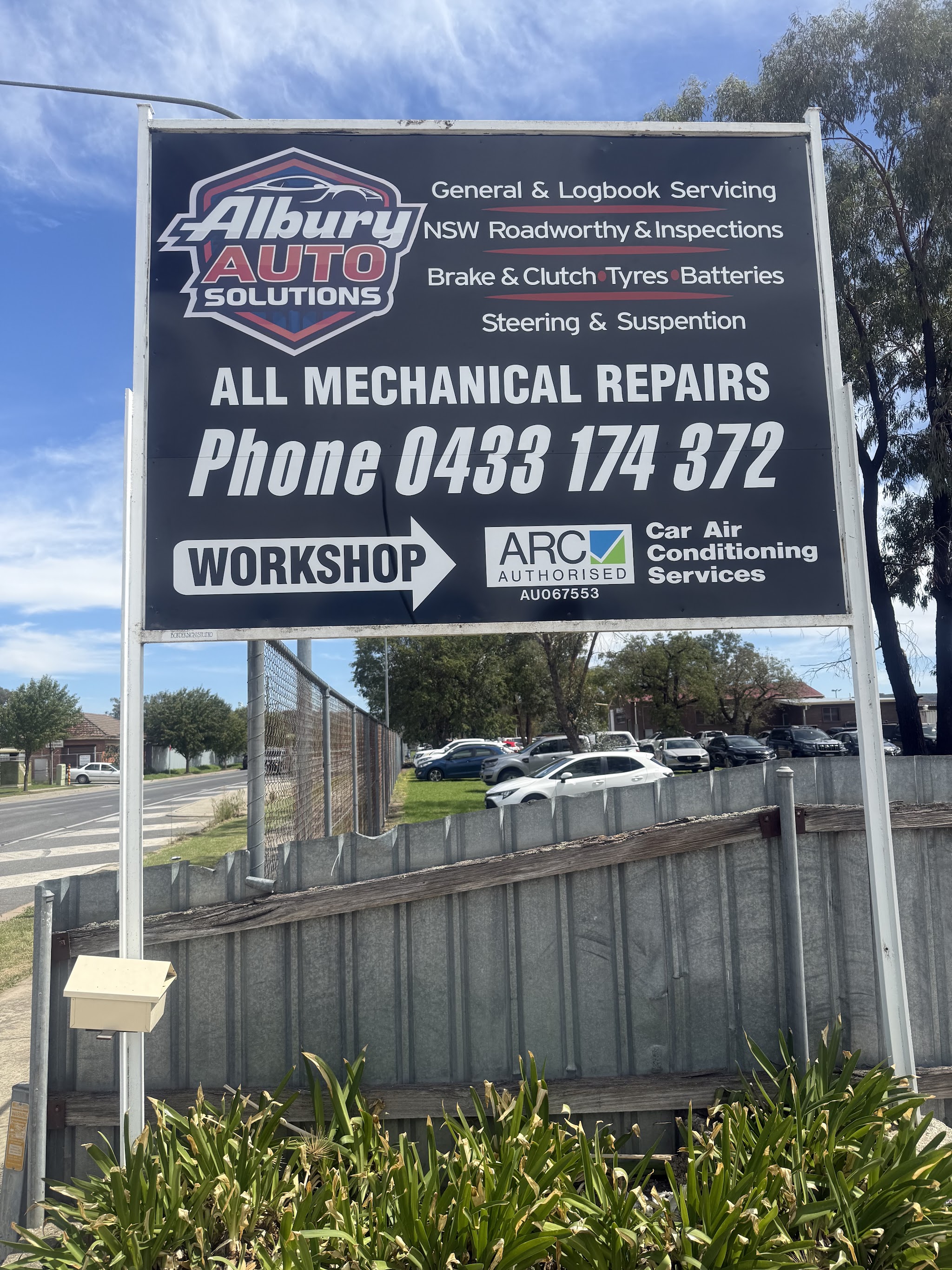 The Albury Auto Solutions sign listing servicing, roadworthy inspections, brakes, clutch, tyres, batteries, steering and suspension